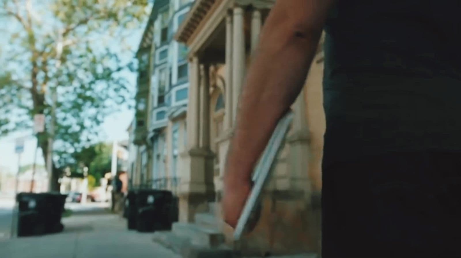 Cinematic street scene with a hand holding a phone